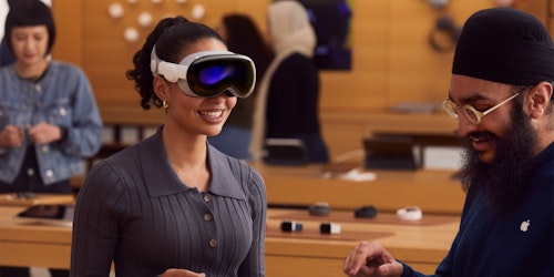A customer being fitted for a Vision Pro headset by an Apple employee at an Apple store A customer being fitted for a Vision Pro headset by an Apple employee at an Apple store