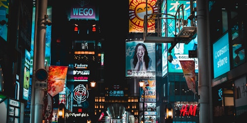 A cityscape of billboards showing different adverts above the heads of a crowd of shoppers A cityscape of billboards showing different adverts above the heads of a crowd of shoppers