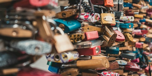 Numerous colorful padlocks attached to a surface Numerous colorful padlocks attached to a surface