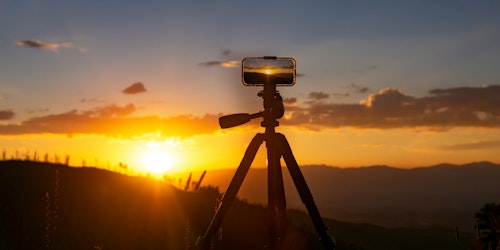 A phone set up to film a sunset A phone set up to film a sunset
