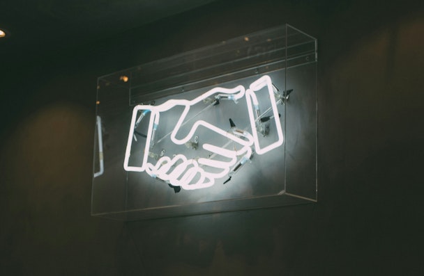 A neon sign of shaking hands A neon sign of shaking hands