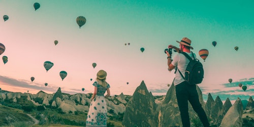 Two travel influencers amid a field of hot-air balloons Two travel influencers amid a field of hot-air balloons