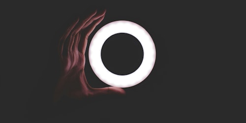 A hand shaping itself around the outside of a light-ring A hand shaping itself around the outside of a light-ring