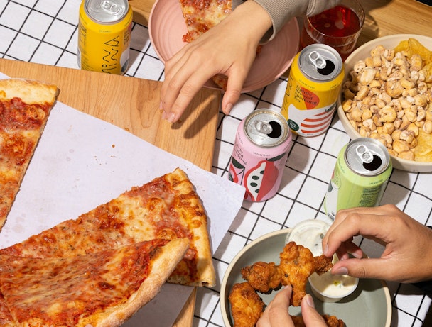 Three hands pick at different snacks laid out on a table Three hands pick at different snacks laid out on a table