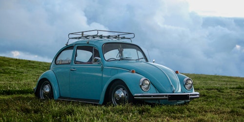 An old blue car in a field An old blue car in a field