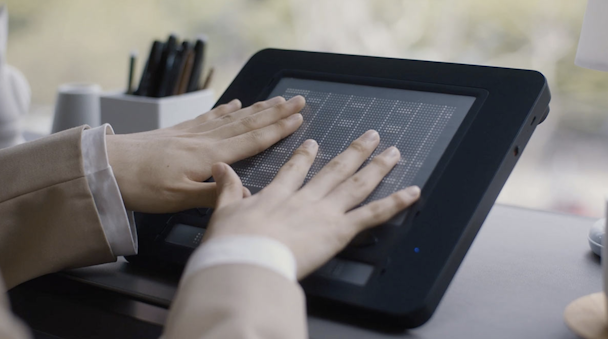 A pair of hands on top of the Dot Pad A pair of hands on top of the Dot Pad