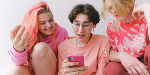Gen z looking at phone dressed in pink Gen z looking at phone dressed in pink