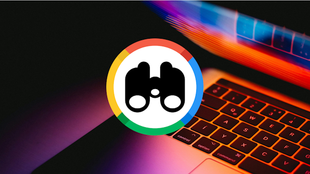 Binoculars with Google colors on background of laptop keyboard Binoculars with Google colors on background of laptop keyboard
