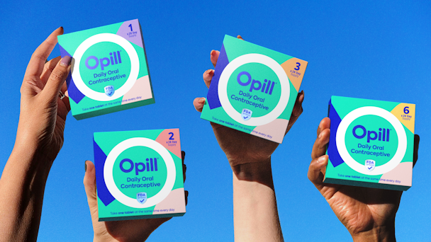 Packets of Opill held aloft by hands Packets of Opill held aloft by hands